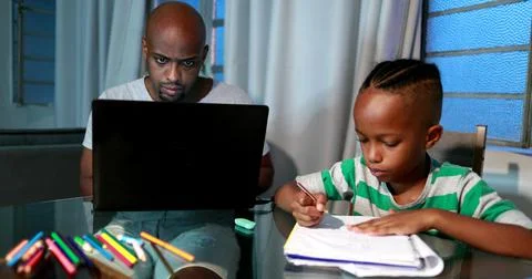 Father multi-tasking using computer laptop at home. Candid authentic and real Foto stock