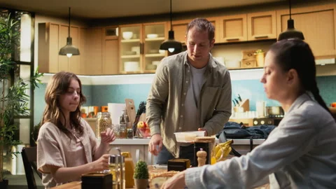 Father packing school lunch for his pre-teen daughter and preparing backpack Stock Footage 326833627