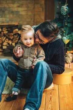 Father playing with her son near Christmas Tree in Christmas evening Stock Photos
