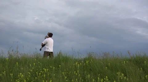 Father playing with his son on spring hill, rise up, dance, dramatic sky 4K Stock Footage 46206050