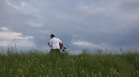 Father playing with his son on spring park, dramatic sky Stock Footage 46206794