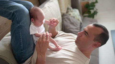 Father playing with infant on sofa Stock Footage 269352538
