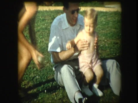 Father playing with kids outside on backyard lawn Stock Footage