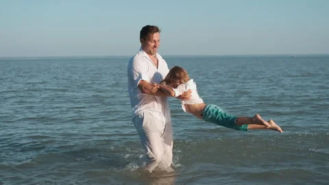 Father plays with his son while swimming in the sea. Stock Footage 248894514