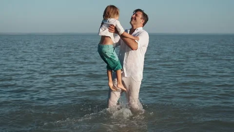 Father plays with his son while swimming in the sea. Stock Footage 248894679