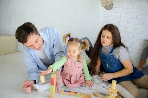 Father plays with two daughters. Stock Photos