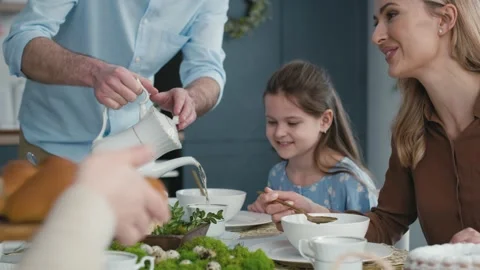 Father pouring tea during easter dinner Stock Footage 170876543