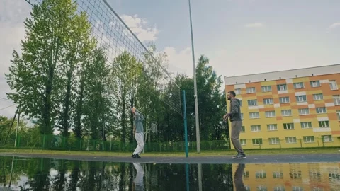 Father practicing volleyball techniques with young daughter at playground Video stock 317485076