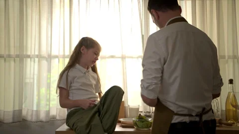 Father preparing a healthy breakfast while his daughter sits on the kitchen 스톡 동영상 340938101
