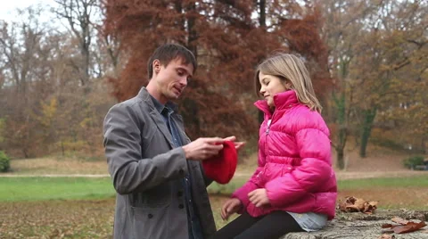 Father putting red cap on daughter's head Stock Footage 59553967