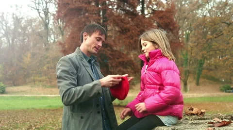Father putting red cap on daughter's head Stock Footage 59553968