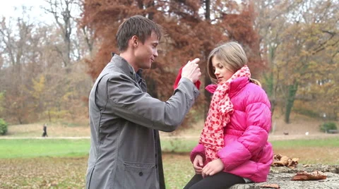 Father putting red cap on daughter's head Stock Footage 59553977