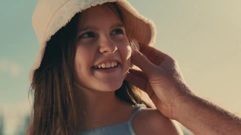 Father putting a seashell to his daughter's ear so she can hear the ocean Stock Footage 262392491