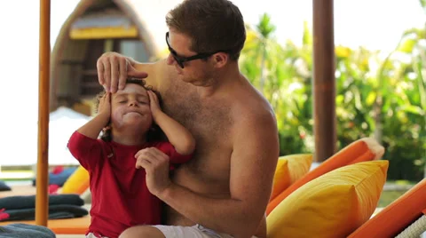Father putting sunscreen on sons face, steadycam shot Stock Footage 39882419
