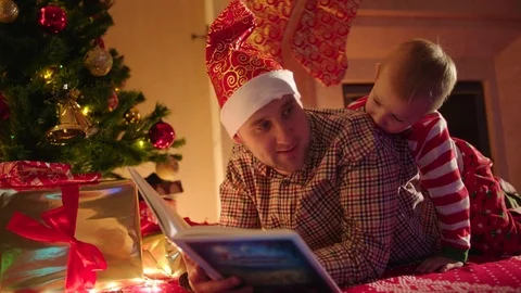 Father reading book to his son on Christmas Eve Stock Footage 73008967