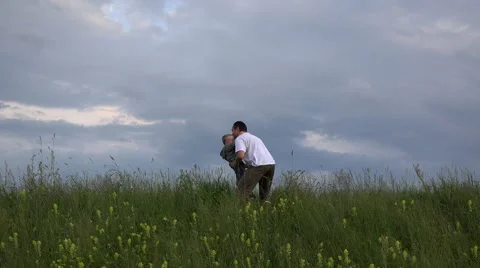 Father rising up boy to dramatic sky, spring park 4K Stock Footage 46206120
