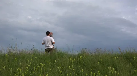 Father rising up his son to dramatic sky, spring hill 4K Stock Footage 46206073