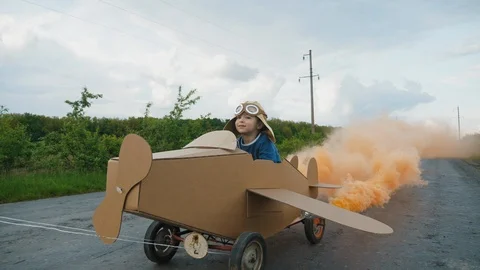 Father rolls his son on a homemade cardboard plane Vidéo 107967341
