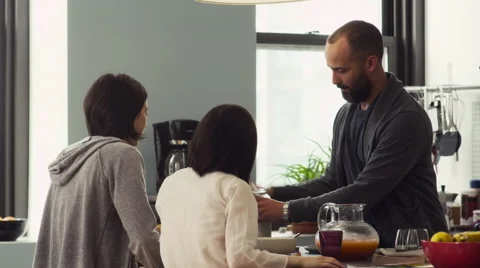 Father serving breakfast to his daughters in kitchen Stock Footage 63861038