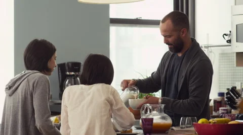 Father serving breakfast to his daughters in kitchen Stock Footage 63861039