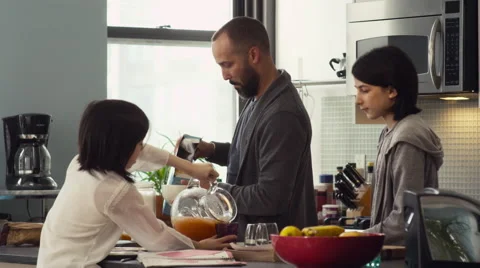 Father serving breakfast to their daughters in kitchen Stock Footage 63861021
