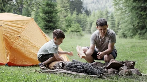 Father showing his son how start a fire campfire during trip in natural environm Stock Footage 249969865
