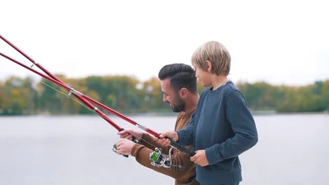 Father shows son how to fish Stock Footage 80839382