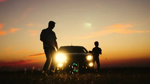 Father son dancing at sunset near car silhouettes. Man dad boy kid child at Stock Footage 280347297