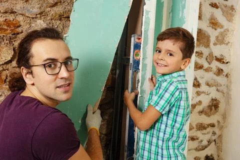 Father with son holding level doing renovation at his home Stock Photos