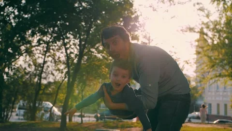 Father with son play in the park in spring. Fly like airplanes. Happy. Stock Footage 320830535