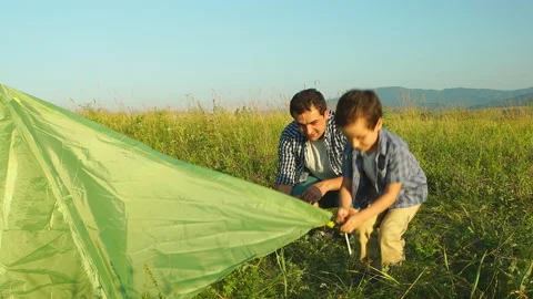 Father with son together are setting a tourist tent Stock Footage 143231836