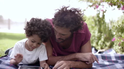 Father with son using digital tablet at park. Stock Footage 63511015