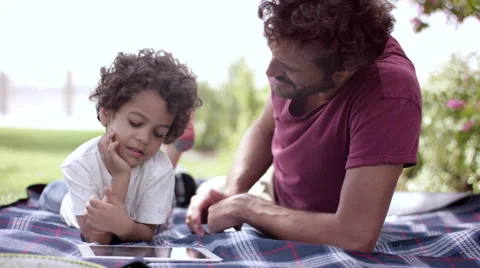 Father with son using digital tablet at park. Stock Footage 63513625