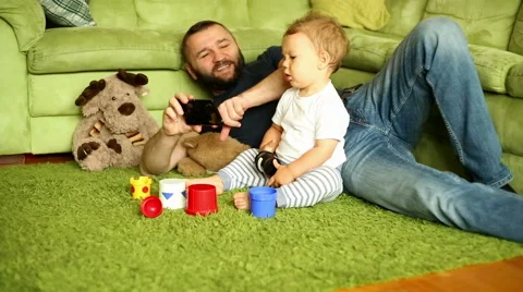 Father is spending time with son, holding a smartphone Stock Footage