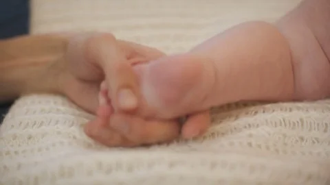 Father stroking the baby's foot Stock Footage 83040309