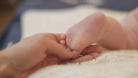 Father stroking the baby's foot Stock Footage 83040369