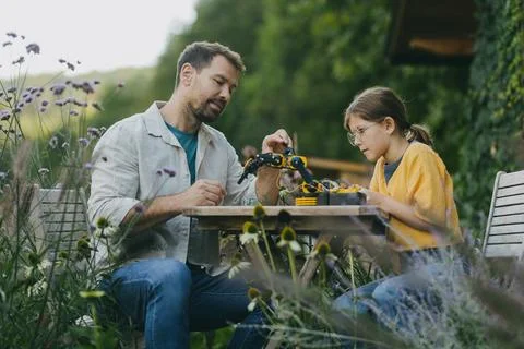 Father supporting daughter in pursuing robotics, science, IT technologies and Stock Photos