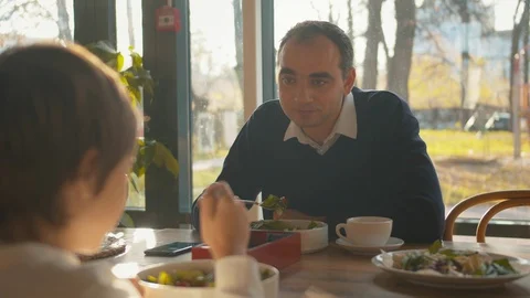 Father talks to son during lunch in cafe Stock Footage 120732608
