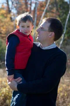 Father talks to son outside in fall Stock Photos
