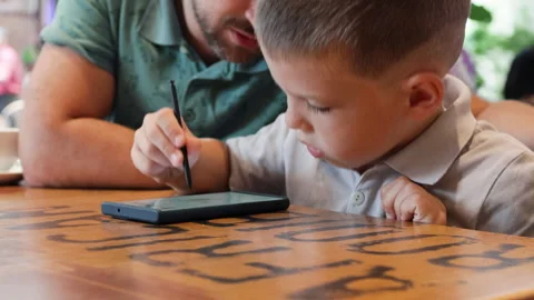 Father teaches his son using smartphone. Stock Footage 287985141