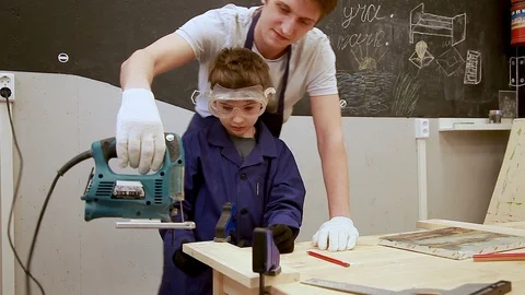 Father teaches his son to work with joinery tools on the workbench Stock-Footage 102239472