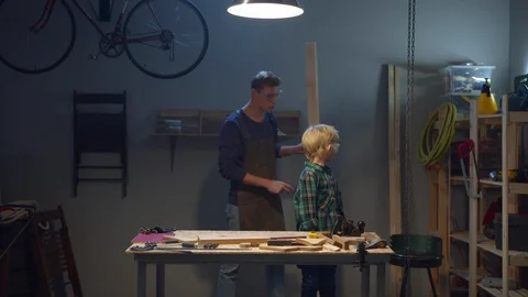 Father teaches son the work of a carpenter Stock Footage 128202925