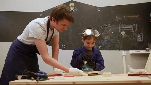 Father teaches son to work as a grinder in the workshop Stock Footage 102240808