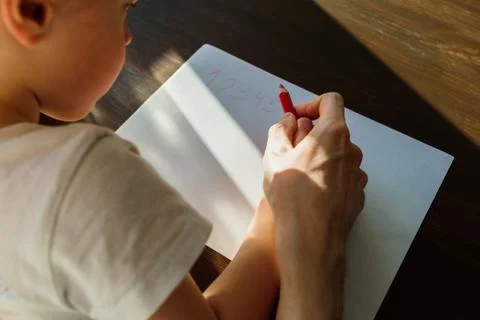 Father teaching child to write or draw Stock Photos