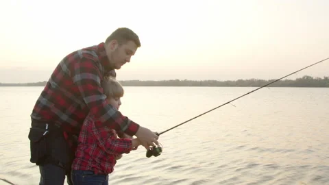 Father teaching daughter to catch fish in morning Stock Footage 143913005