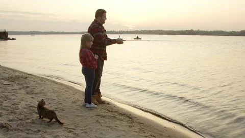 Father teaching daughter to catch fish in morning Stock-Footage 143913748