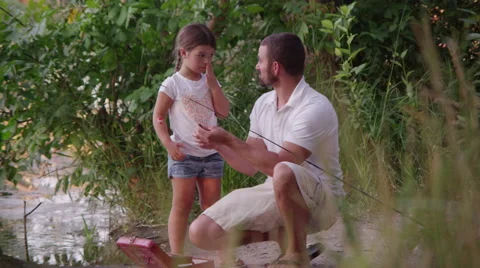 Father teaching daughter how to fish and bait Video stock 67299331