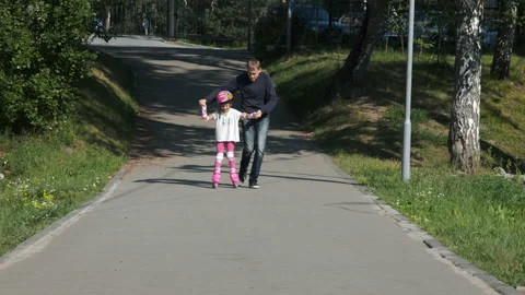 Father Teaching Daughter Inline Skating in Park Vídeo Stock 136426395