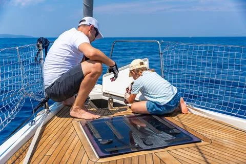 Father teaching his daughter basic yacht maintenance during a family sailing Photos