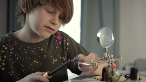 Father teaching his little son to solder electronic contacts at home. Stock Footage 169463533